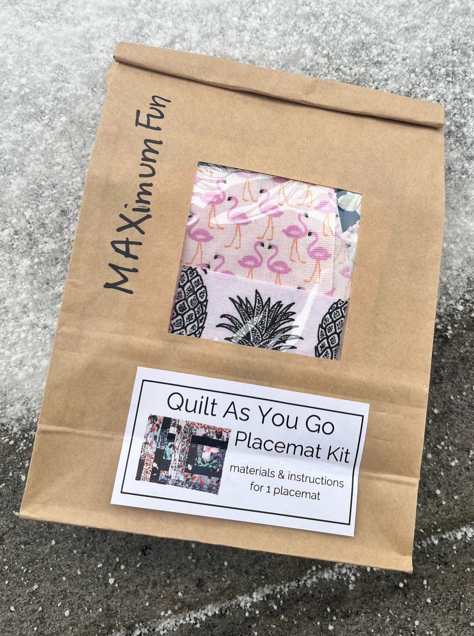 brown bakery bag full of fabric for a Quilt As You Go Placemat kit